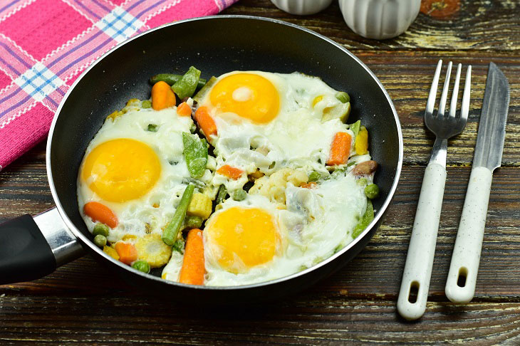 Fried eggs with vegetables in a pan - easy to prepare and very tasty
