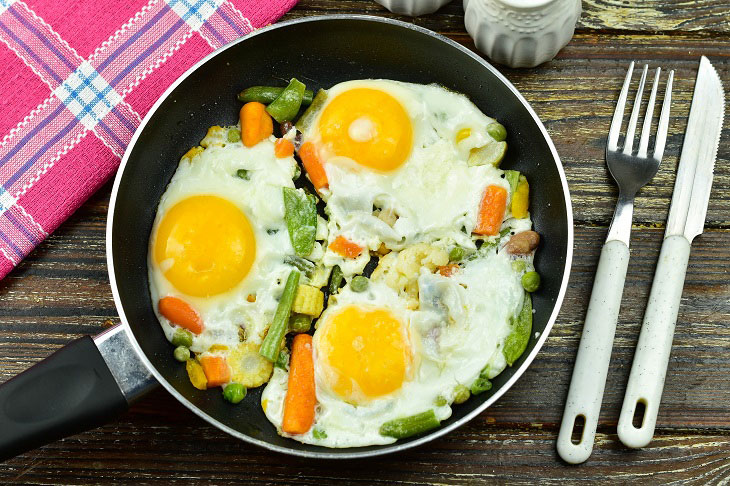 Fried eggs with vegetables in a pan - easy to prepare and very tasty