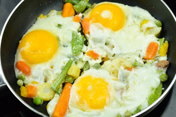 Fried eggs with vegetables in a pan - easy to prepare and very tasty