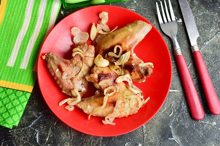 Chicken wings on an onion pillow - tasty and appetizing