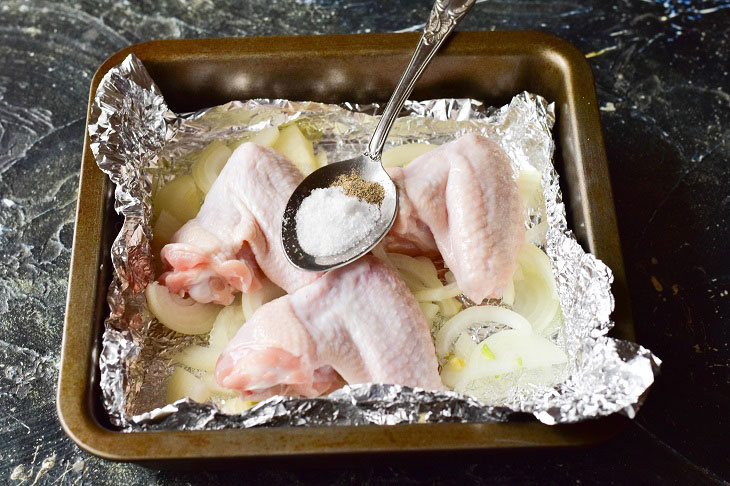 Chicken wings on an onion pillow - tasty and appetizing