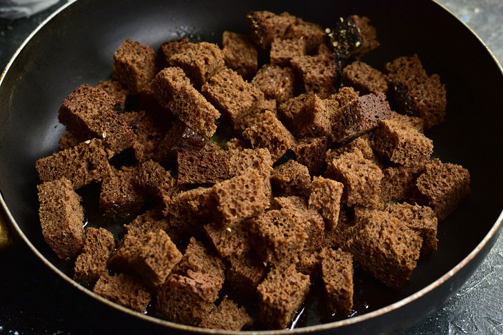 Homemade garlic croutons in a pan - a quick and flavorful snack