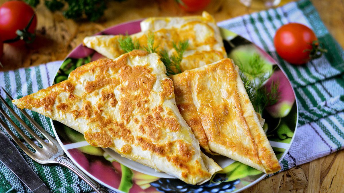 Triangles of pita bread with cheese in a pan – a great snack for all times