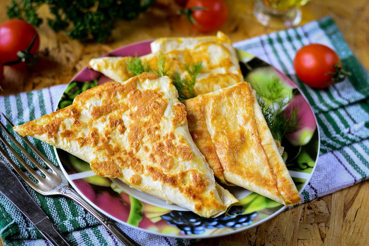 Triangles of pita bread with cheese in a pan - a great snack for all times