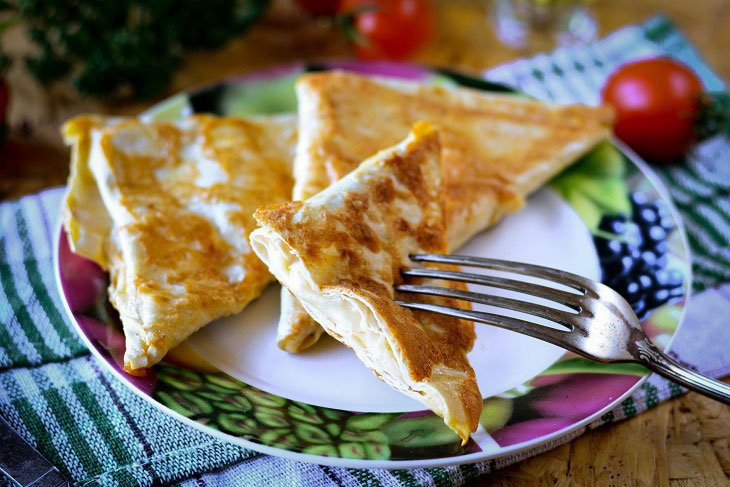 Triangles of pita bread with cheese in a pan - a great snack for all times