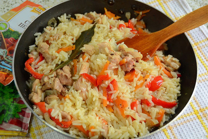 Fried rice with chicken and vegetables in a pan - a hearty and budget dinner