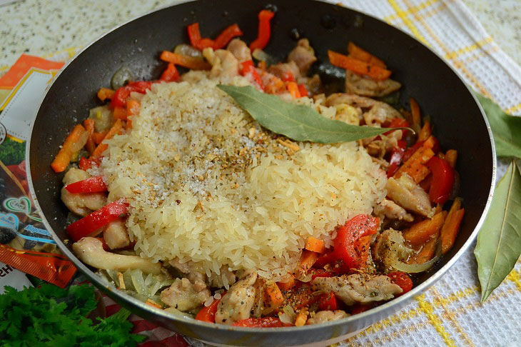 Fried rice with chicken and vegetables in a pan - a hearty and budget dinner