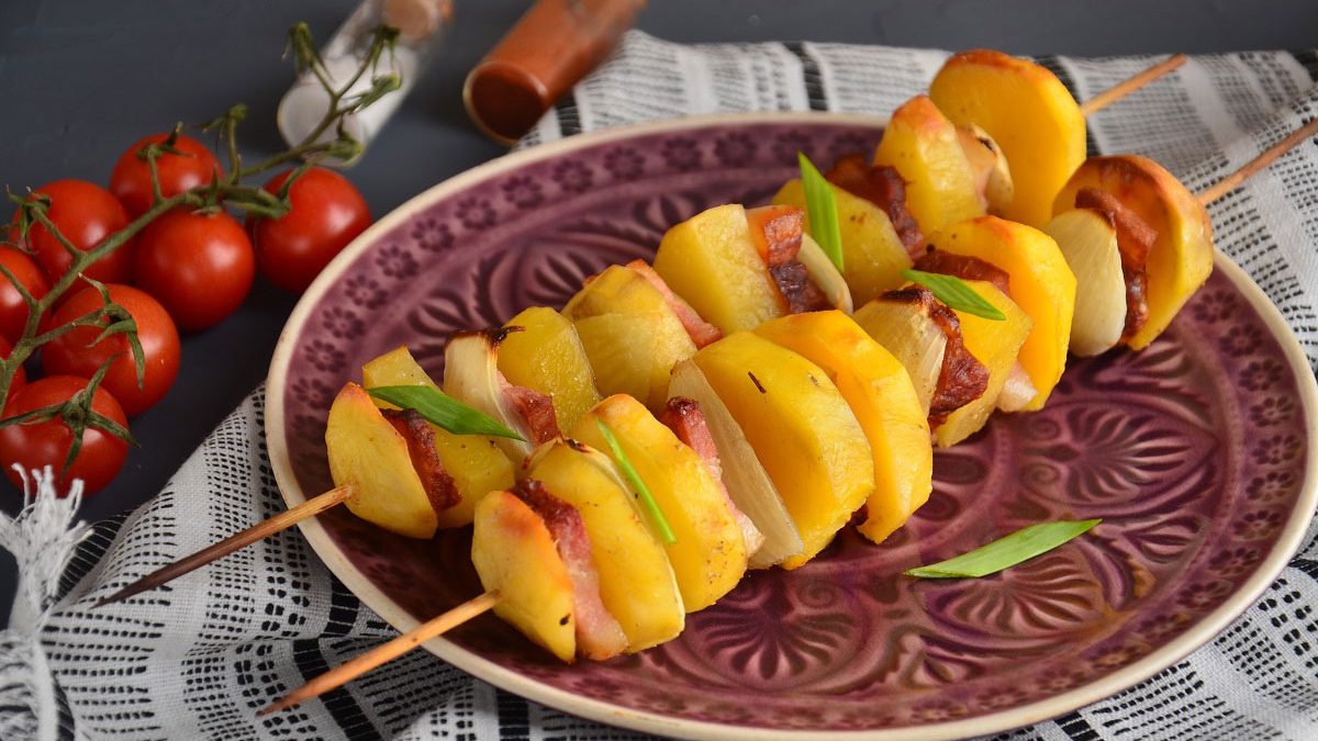 Potatoes with brisket and onions baked on skewers in the oven