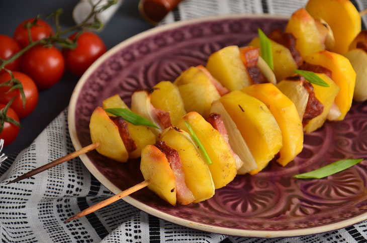 Potatoes with brisket and onions baked on skewers in the oven