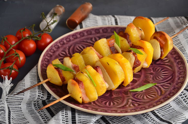 Potatoes with brisket and onions baked on skewers in the oven