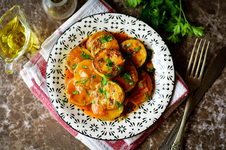 Zucchini stewed in tomato sauce in a pan - unusual and bright in taste