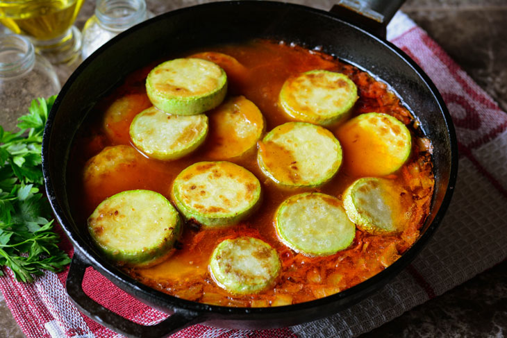 Zucchini stewed in tomato sauce in a pan - unusual and bright in taste