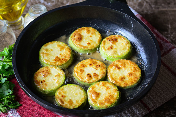 Zucchini stewed in tomato sauce in a pan - unusual and bright in taste