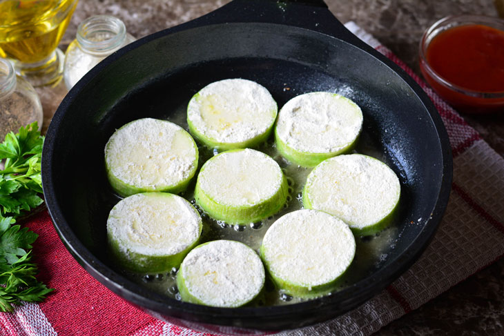 Zucchini stewed in tomato sauce in a pan - unusual and bright in taste